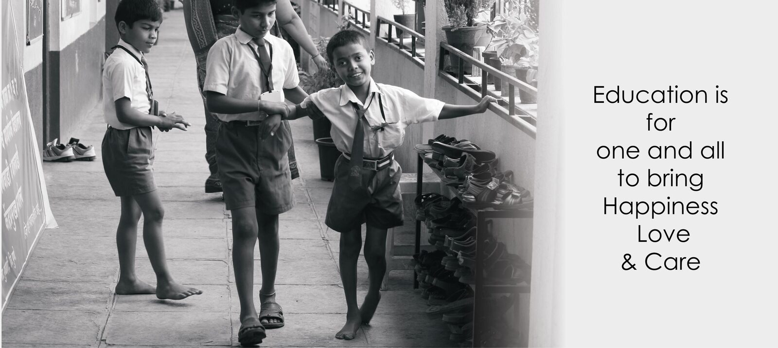 Students of a founding-program school, barefoot and in uniform, walking a school corridor.